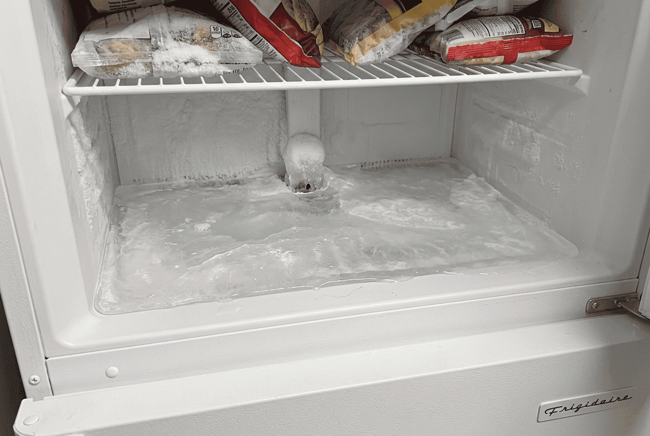 Ice buildup on freezer floor of Frigidaire refrigerator caused by frozen defrost drain line