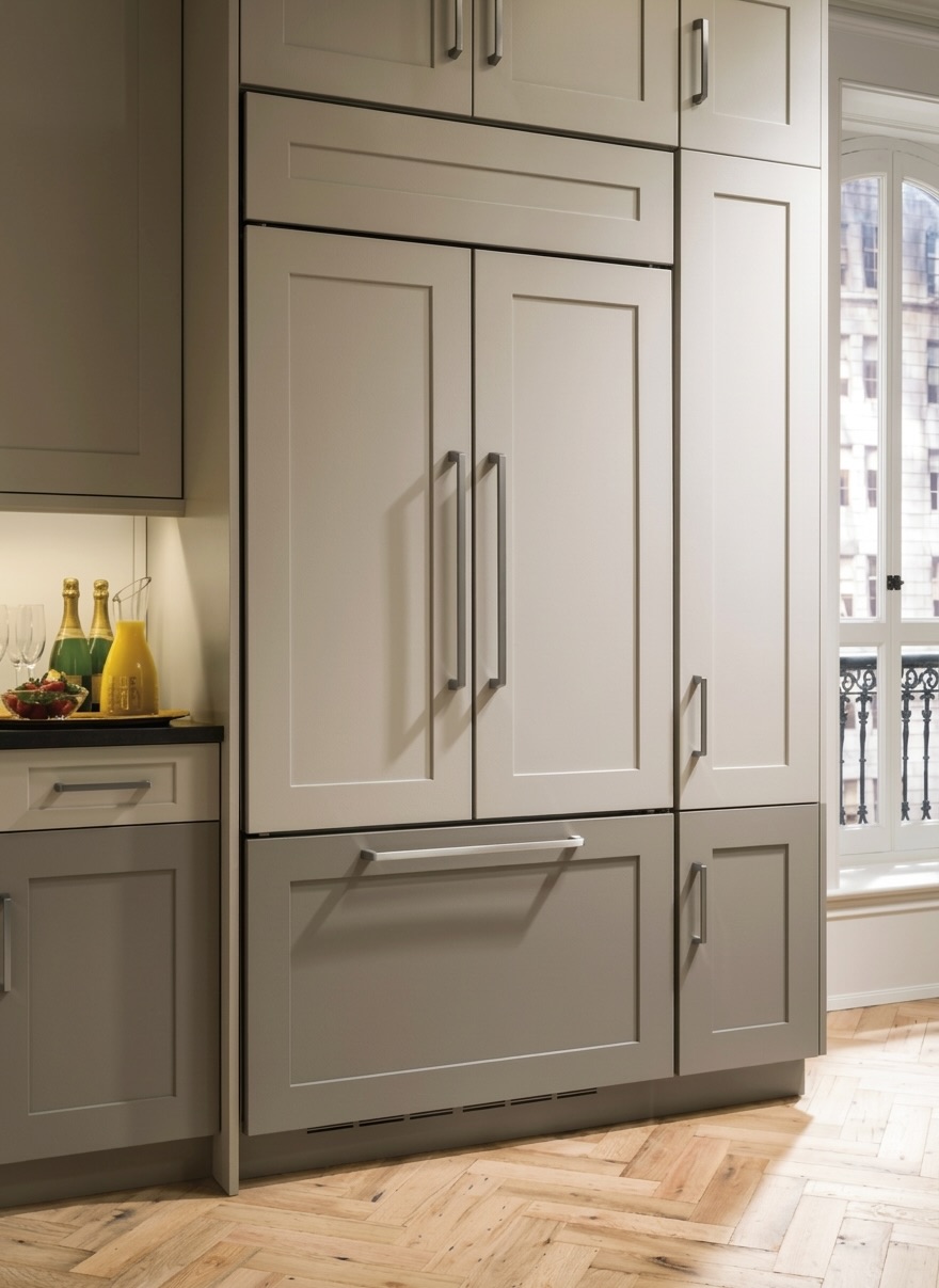 Closed Monogram ZIP360NH panel-ready French-door refrigerator integrated in gray kitchen cabinetry with custom panels and handles, area prone to making loud noise from internal fans or compressor